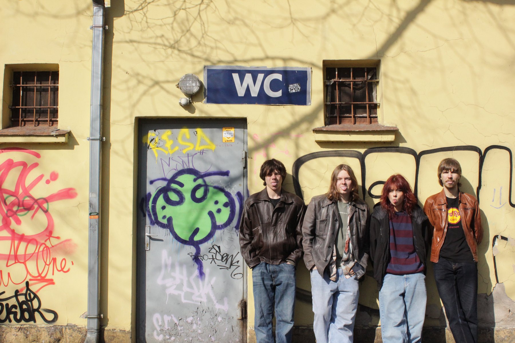 Grupa Utopia pie dzeltenas sienas ar grafiti